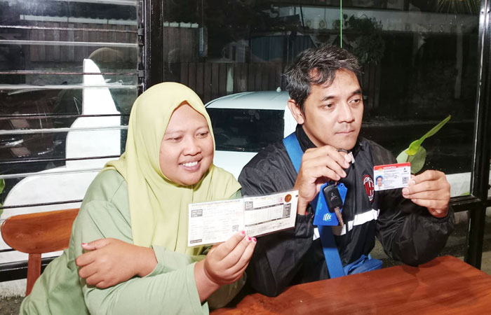 LEGA: Hogi Minaya dan Arsita menunjukkan barang bukti STNK mobil berikut SIM-nya yang telah dikembalikan.
