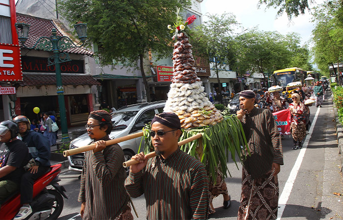 NGURI-URI TRADISI: Warga Kampung Suryatmajan saat mengarak apem dalam tradisi ruwahan dan ngapemam di kawasan Malioboro, kemarin (3/2).