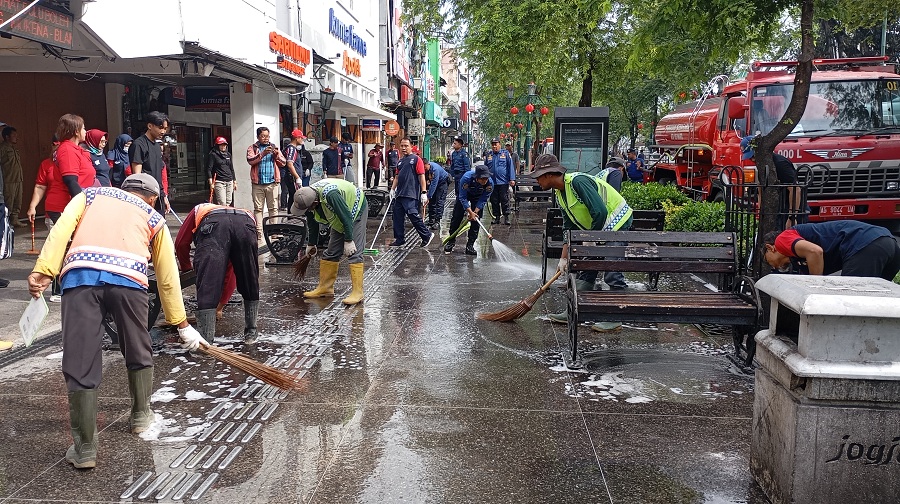 TURUN : Armada mobil pemadam kebakaran atau gajah merah dan petugas pemadam saat membersihkan area pedestrian Malioboro, Jumat (6/2/2026).