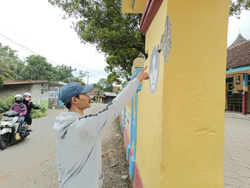 RUSAK: Warga menunjukkan kerusakan pada bagian gerbang pagar SDN 1 Clapar, Kecamatan Karanggayam setelah ditabrak mobil SPPG.