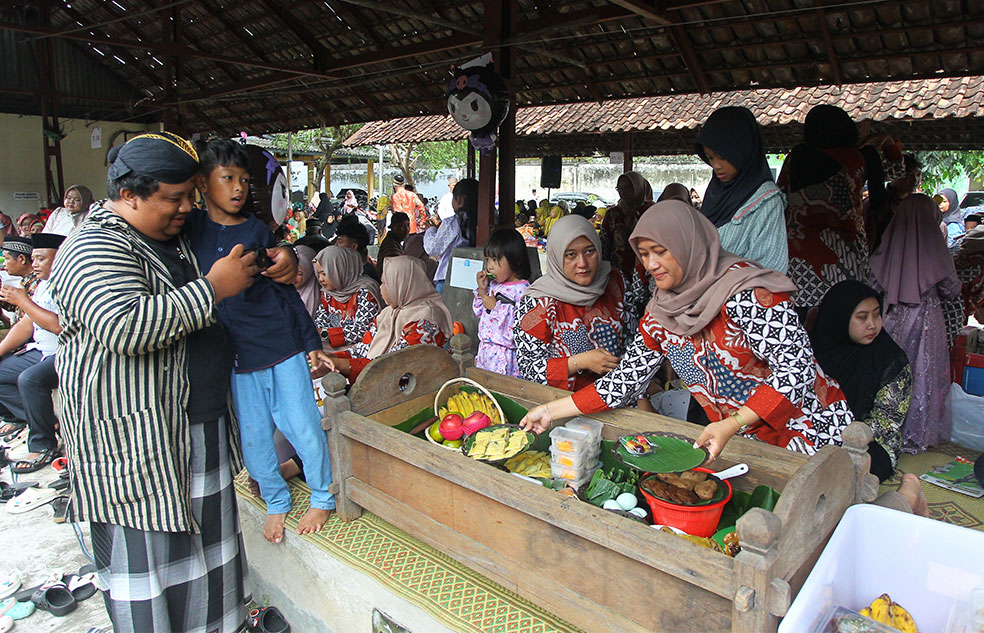 Warga makan bersama dalam tradisi Nyadran Pasar, di Pasar Wonosari, Wedomartani, Ngemplak, Sleman, kemarin (8/2). Tradisi nyadran tersebut sebagai wujud syukur