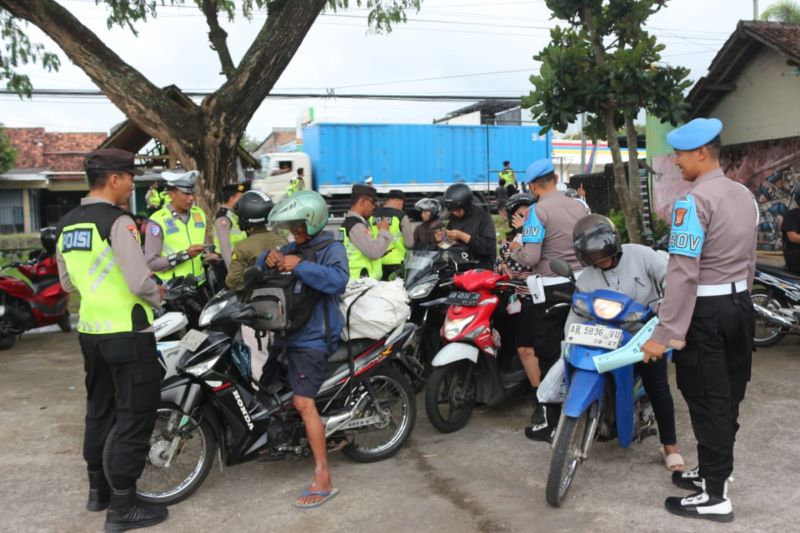 Polisi sedang memberhentikan kendaraan bermotor untuk dicek kelengkapan kendaraannya