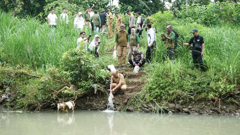 TEBAR: Wartawan dan unsur Pemkab Kulon Progo melakukan tebar benih di Sungai Serang.