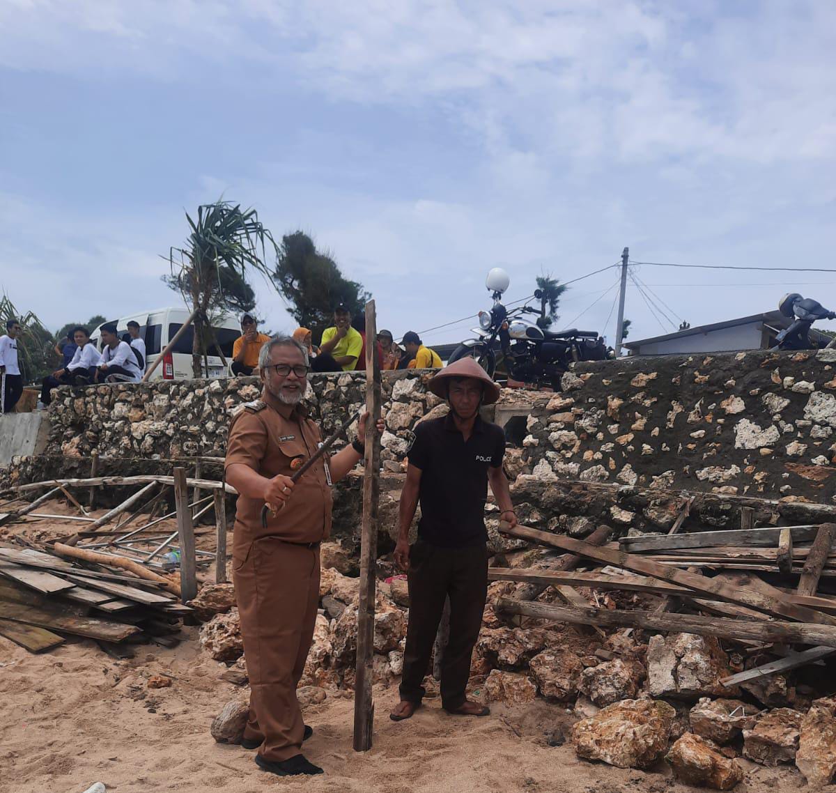 Kepala Disparekrafpora Haru Sukmono sedang dibantu pedagang melakukan pembongkaran tempat duduk semi permanen di Pantai Sepanjang.
