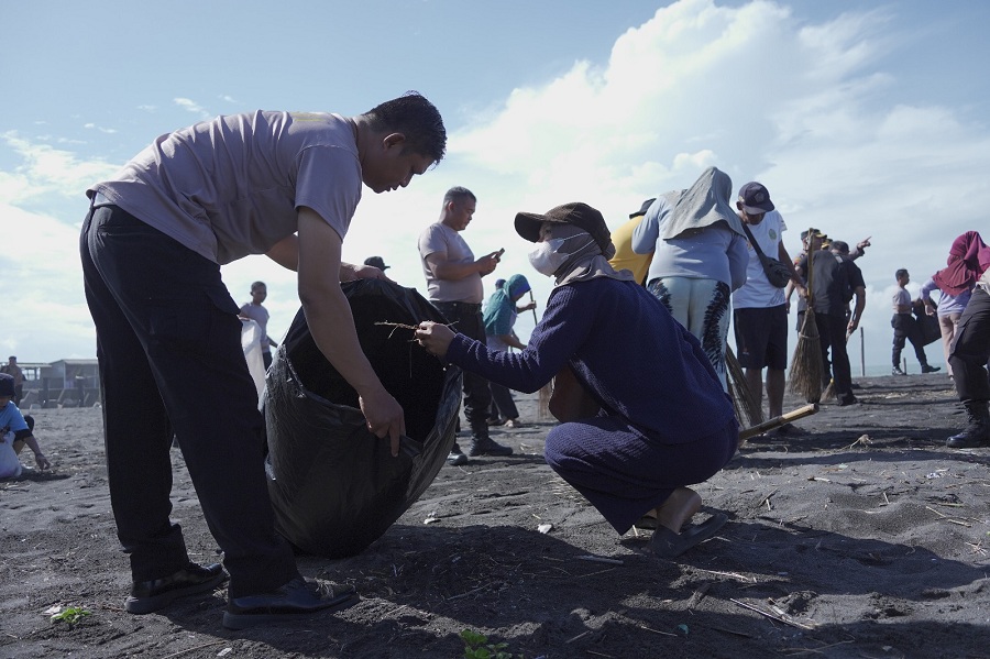 PEMBERSIHAN: Personel Polres Kulon Progo dan masyarakat gerak cepat mengumpulkan sampah di Pantai Congot.
