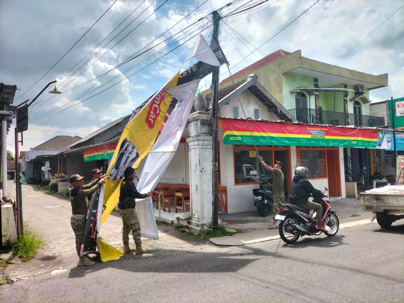 MELANGGAR: Satpol PP Bantul sedang menertibkan spanduk yang melanggar Perda Bantul Nomor 10 Tahun 2020.