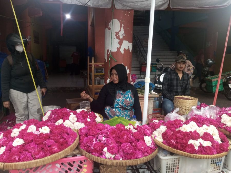 LARIS MANIS: Pedagang kembang pasar argosari sedang melayani pembeli Jumat (13/2/2026) sore.