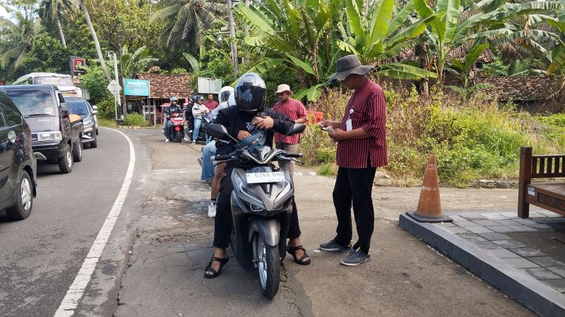 KUNJUNGAN NAIK: Petugas TPR Parangtritis sedang memungut retribusi wisatawan yang akan memasuki kawasan pantai Bantul Minggu (15/2).