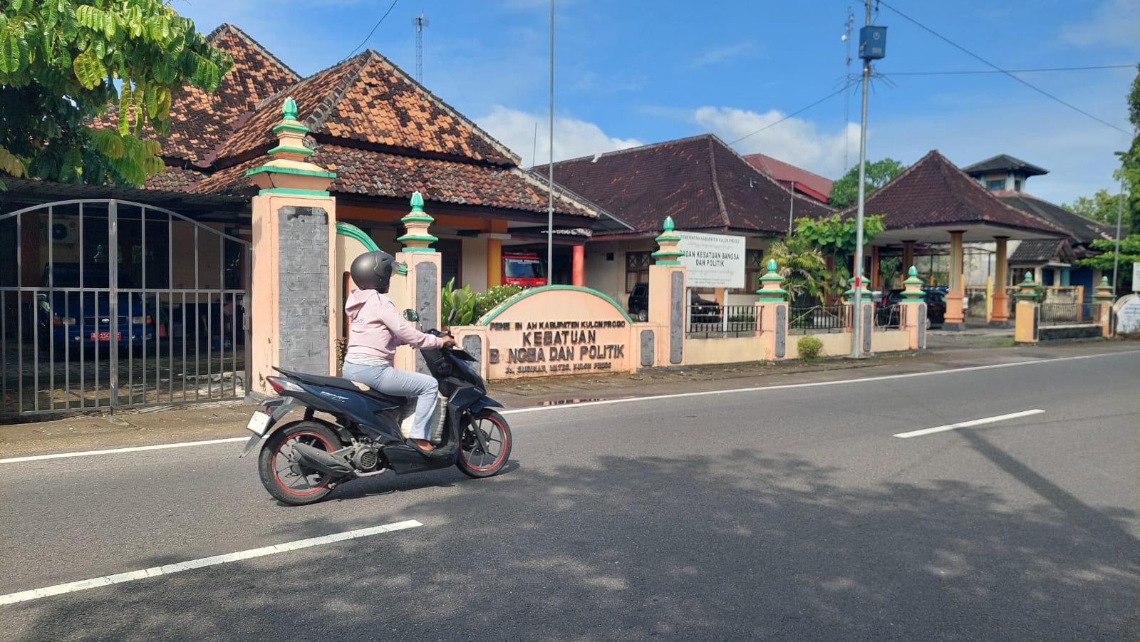 RAMAI: Pengendara sepeda motor melewati Kantor Kesbangpol yang belum berwarna kuning dan hijau.
