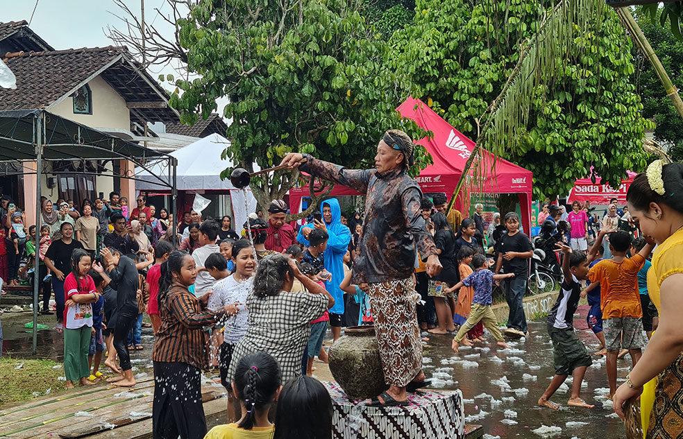 RAMAI: Anak-anak hingga orang dewasa saling melempar air pada tradisi Bajong Banyu di Lapangan Dusun Dawung, kemarin (15/2).