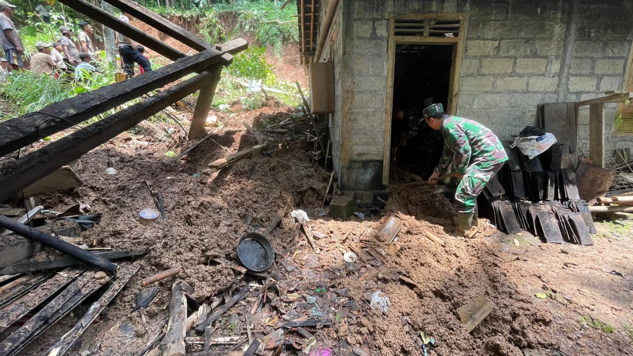 RATA: Material longsor menutup rumah Iswanto mulai dibersihkan aparat kepolisian dan TNI.&nbsp;