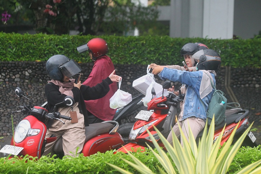 Mahasiswa memotret takjil yang mereka peroleh saat pembagian takjil gratis di Kampus Universitas Muhammadiyah Yogyakarta (UMY), Rabu (18/2/2026).