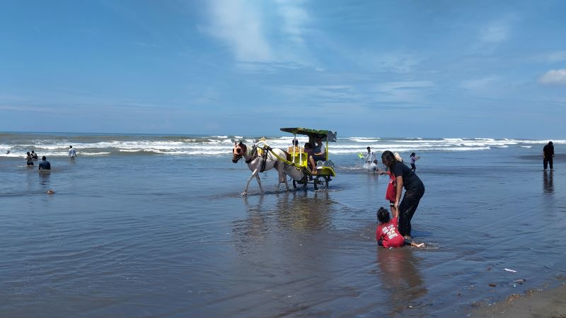 LIBUR PANJANG: Wisatawan sedang bermain air di Pantai Parangtritis saat libur Imlek.