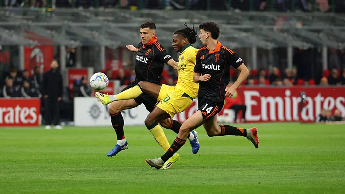Penyerang sayap AC Milan, Rafael Leao coba lewati hadangan dua pemain Como dalam hasil imbang di San Siro