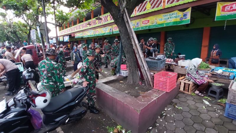 RESIK: Personel TNI dan Kepolisian menyisir area Pasar Wates untuk menyapu serta mengumpulkan sampah.&nbsp;