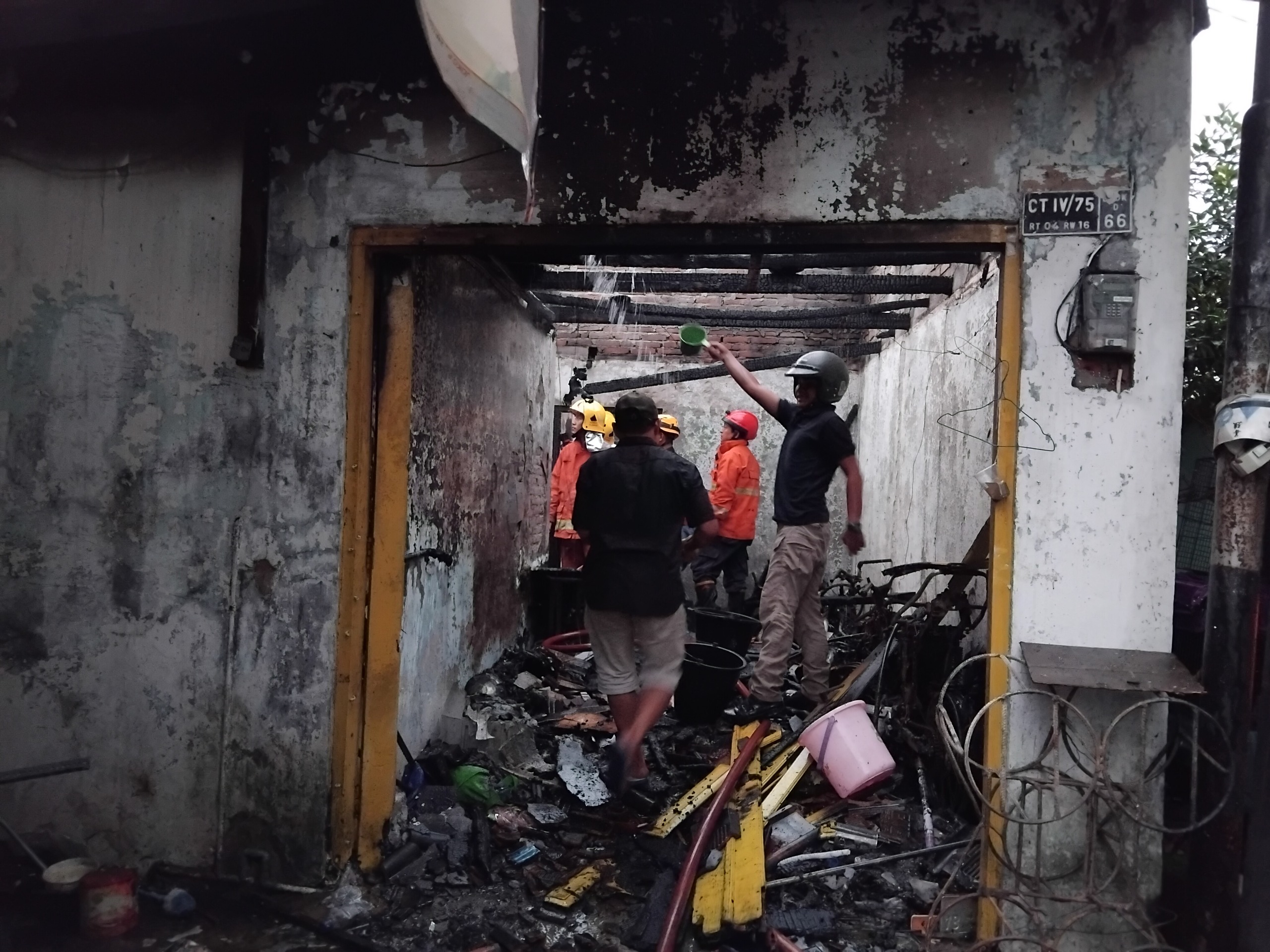 Para petugas Damkar dan warga saat bergotong royong memadamkan api