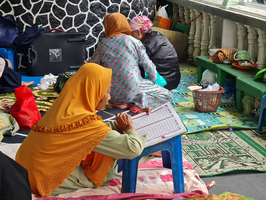KHUSYUK: Santri lansia di Pondok Sepuh, kompleks Masjid Agung Payaman tampak fokus membaca Al-Qur'an sembari menunggu azan Zuhur, Selasa (24/2/2026).
