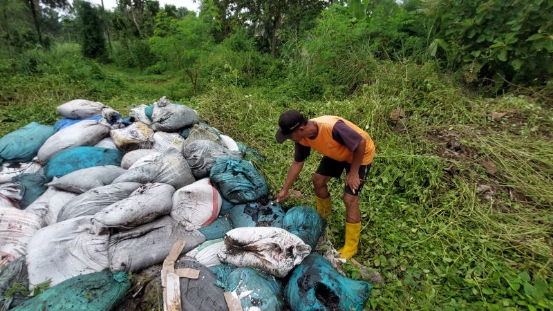 TUMPUKAN: Sriyono menunjukkan karung sampah B3 yang tertumpuk di lahannya.&nbsp;