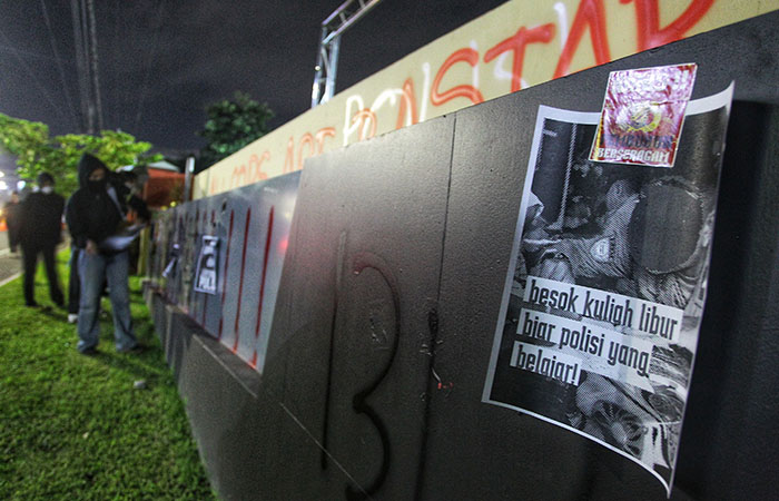 EKSPRESI KEMARAHAN MASYARAKAT: Massa melakukan aksi dengan mencorat-coret dan menempelkan poster di pagar Mapolda DIJ, tadi malam (24/2). Aksi dipicu oleh seorang anak di Tual, Maluku, yang meninggal.