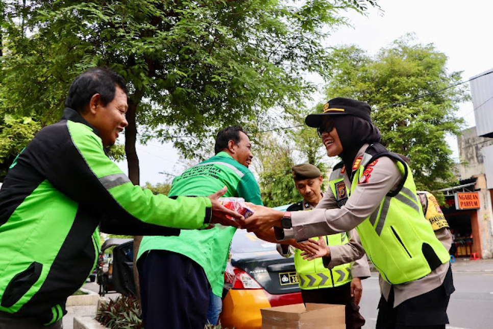 UNTUK BATALKAN PUASA: Kapolsek Ngampilan AKP Sriyati&nbsp; ikut membagikan langsung takjil kepada pengguna jalan, Senin (23/2) sore.