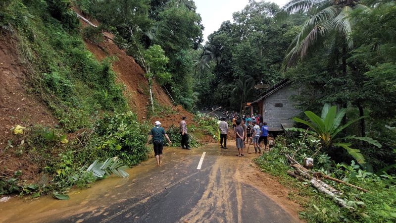 GOTONG ROYONG: Warga Kalurahan Hargotirto bersama-sama membersihkan material longsor yang menutup jalan provinsi Jumat (27/2).