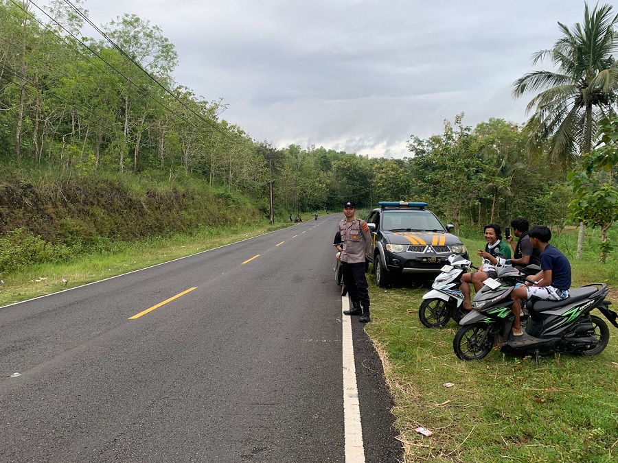 Personel Polsek Saptosari sedang memastikan remaja yang berkumpul di JJLS Monggol tidak melakukan aktivitas kenakalan remaja seperti balap liar dan perang sarung.