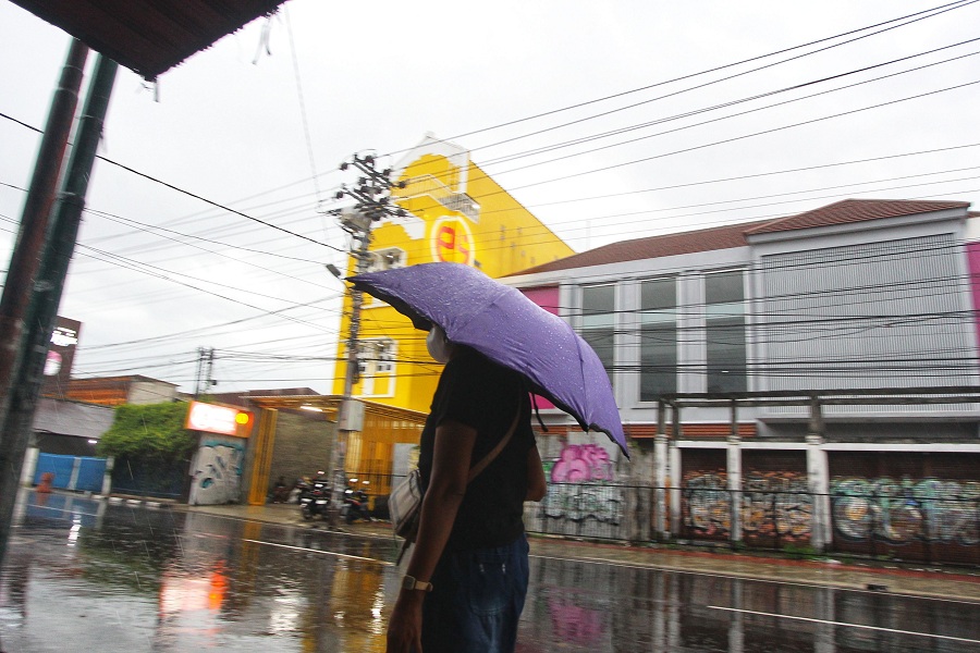 Pejalan kaki menggunakan payung saat hujan mengguyur kawasan Jalan Suryotomo, Kota Jogja, Rabu (4/2/2026). 
