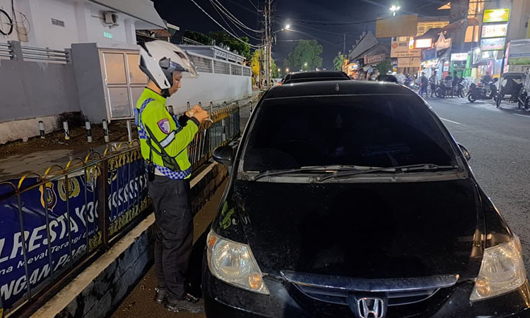 TILANG: Personel Polresta Jogja saat menerapkan sanksi tilang melalui ETLE mobile handheld kepada pelanggar lalu lintas.