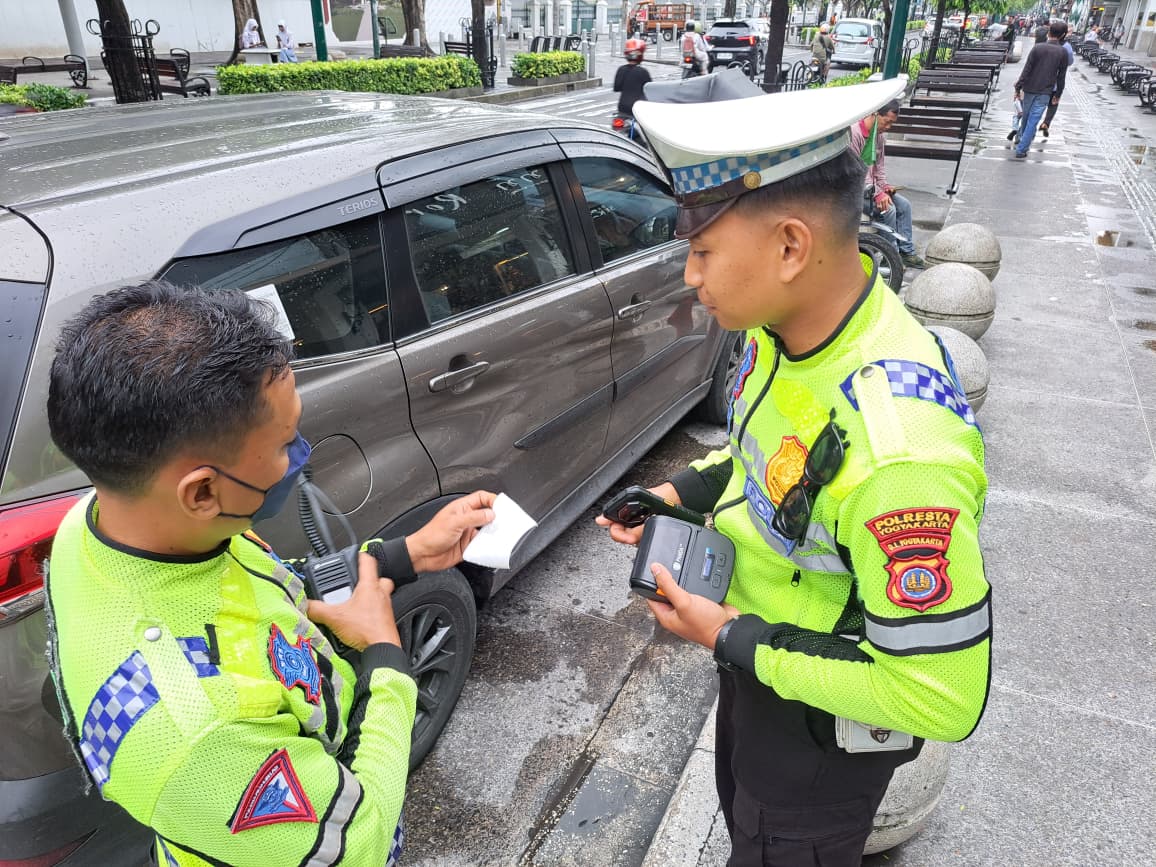 TILANG : Personil Polresta Jogja saat menerapkan sanksi tilang melalui etle mobile handheld kepada pelanggar lalu lintas.