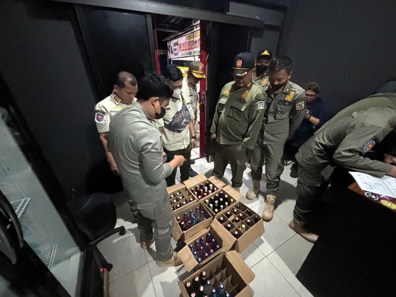 RAZIA: Petugas Satpol PP Sleman saat melakukan penyitaan miras.