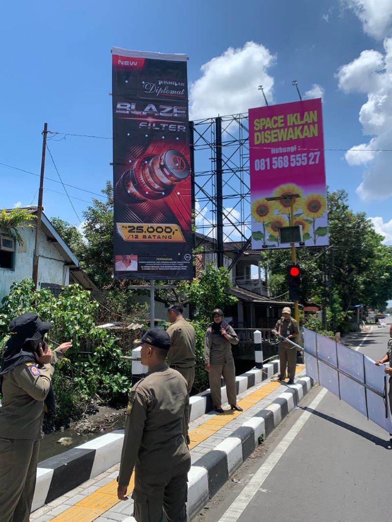 Petugas Satpol PP Bantul sedang menertibkan reklame di simpang tiga Cepit, Pendowoharjo, Sewon Kamis (12/3).
