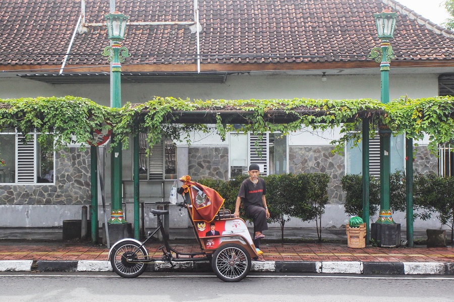 Pengayuh becak listrik menunggu calon penumpang di kawasan Gedongkiwo, Kota Jogja, Selasa (15/3/2026). 