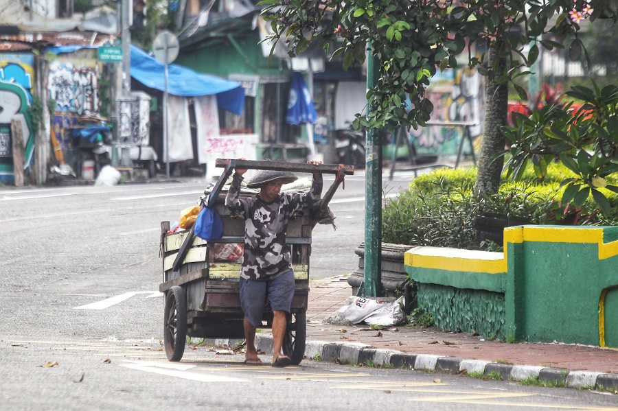 Seorang gelandangan mendorong gerobak berisi barang-barang pribadinya saat melintas di kawasan Kleringan, Kota Jogja.