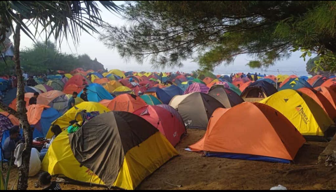Pengunjung Pantai Drini menikmati liburan dengan berkemah. 