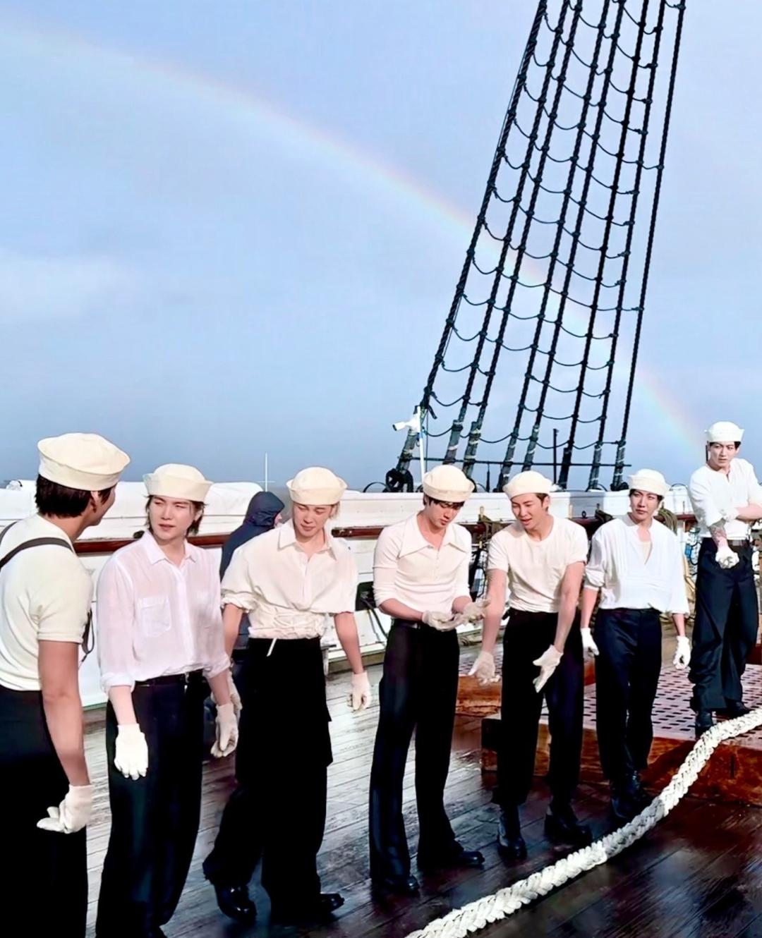 Foto grup tersebut menampilkan ketujuh member BTS mengenakan outfit sailor bergaya nautikal di atas dek kapal. 