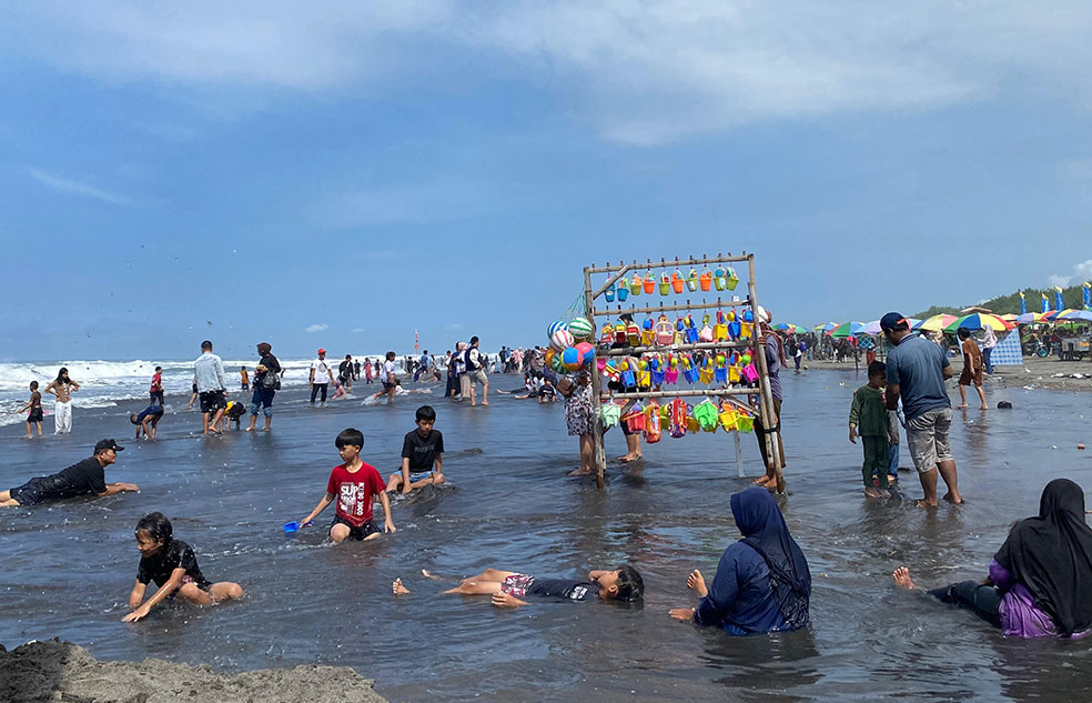 BERLIBUR: Beberapa wisatawan sedang bermain pasir di Pantai Parangtritis, Bantul, Selasa (24/3).