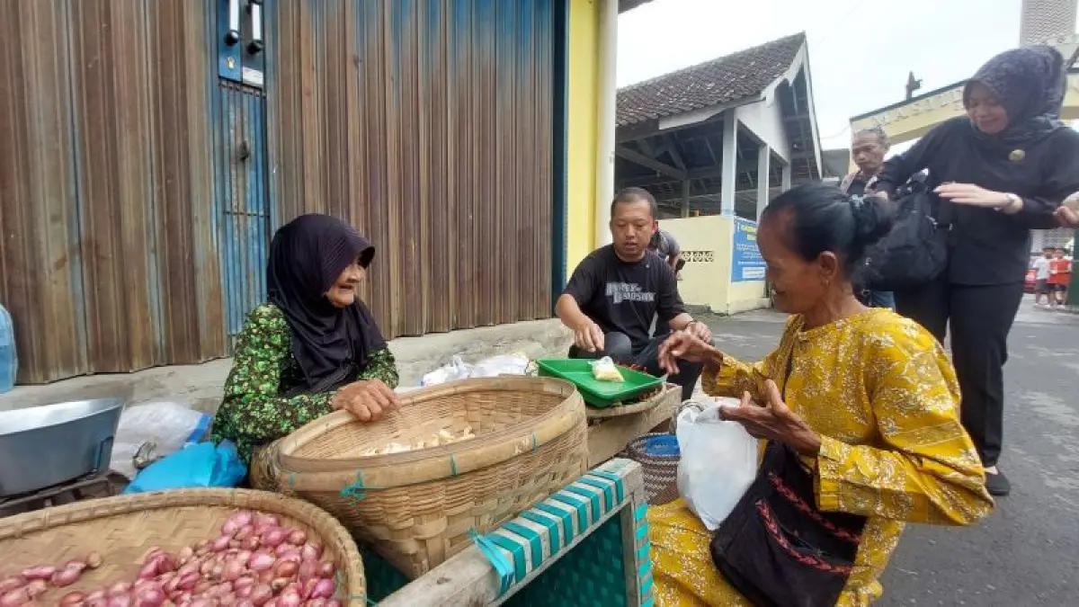 BERBINCANG: Wakil Bupati Kulon Progo Ambar Purwoko membeli sejumlah kebutuhan pokok di pedagang emperan Pasar Bendungan. (ANOM&nbsp;BAGASKORO/RADAR JOGJA)