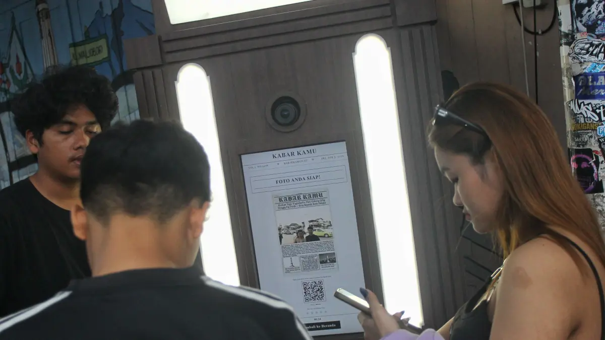 Pengunjung mengabadikan momen menggunakan layanan photobox berlatar belakang Tugu Jogja, kemarin (3/4). Tren photobox dengan latar ikon kota tersebut kian diminati, terutama oleh kalangan muda, karena menawarkan pengalaman berfoto instan dengan suasana ruang publik yang ikonik sekaligus menjadi bagian dari gaya hidup urban