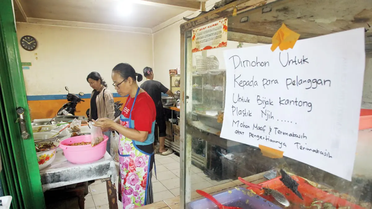 Penjual makanan menempelkan imbauan kepada pembeli untuk bijak menggunakan kantong plastik imbas dari kenaikan harga plastik di warung makan Mbak Yayuk, Jalan DI Panjaitan, Jogja, kemarin (6/4). Meroketnya harga plastik kian membebani pelaku usaha kecil. Guntur Aga Tirtana/Radar Jogja