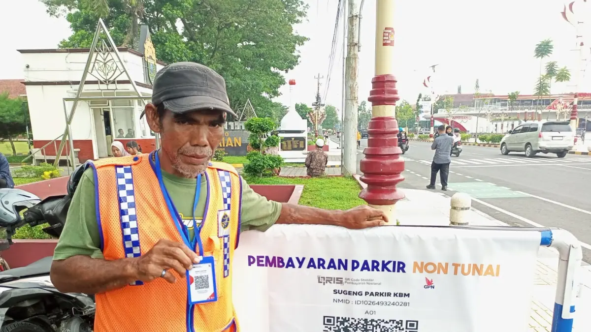 Petugas parkir di depan kompleks Pendopo Kabumian dilengkapi atribut untuk mendukung pembayaran retribusi parkir non tunai. (M Hafied/Radar Jogja)