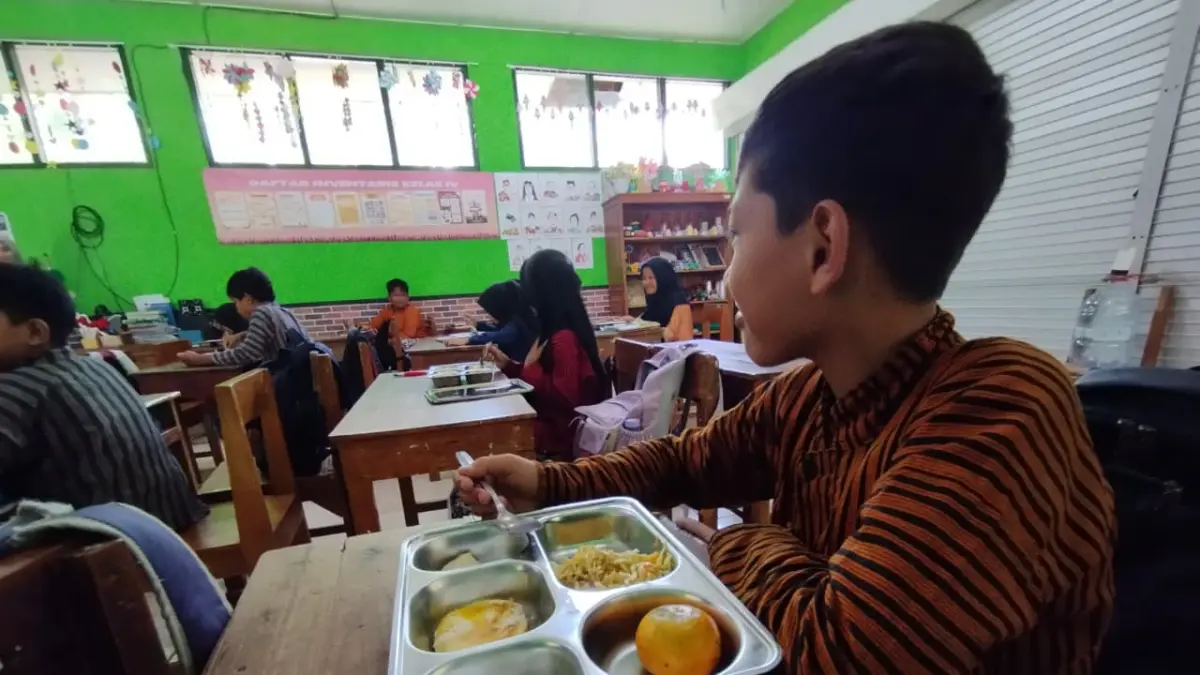 BERGIZI: Siswa sekolah dasar memakan menu MBG di balik ompreng. (ANOM BAGASKORO/RADAR JOGJA)