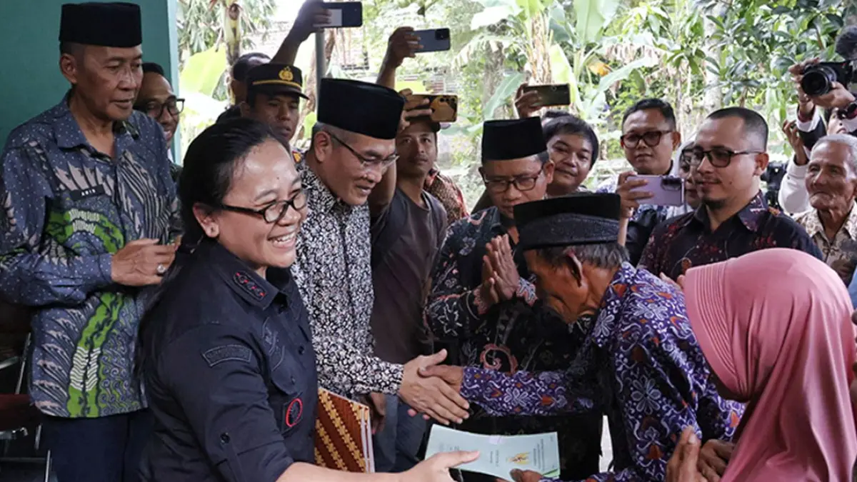 Mbah Tupon memegang sertifikat tanah miliknya yang kini telah kembali. Dalam setahun terakhir, sertifikat tanah itu sempat terjerat kasus mafia tanah.(GUNTUR&nbsp; AGA TIRTANA/RADAR JOGJA)