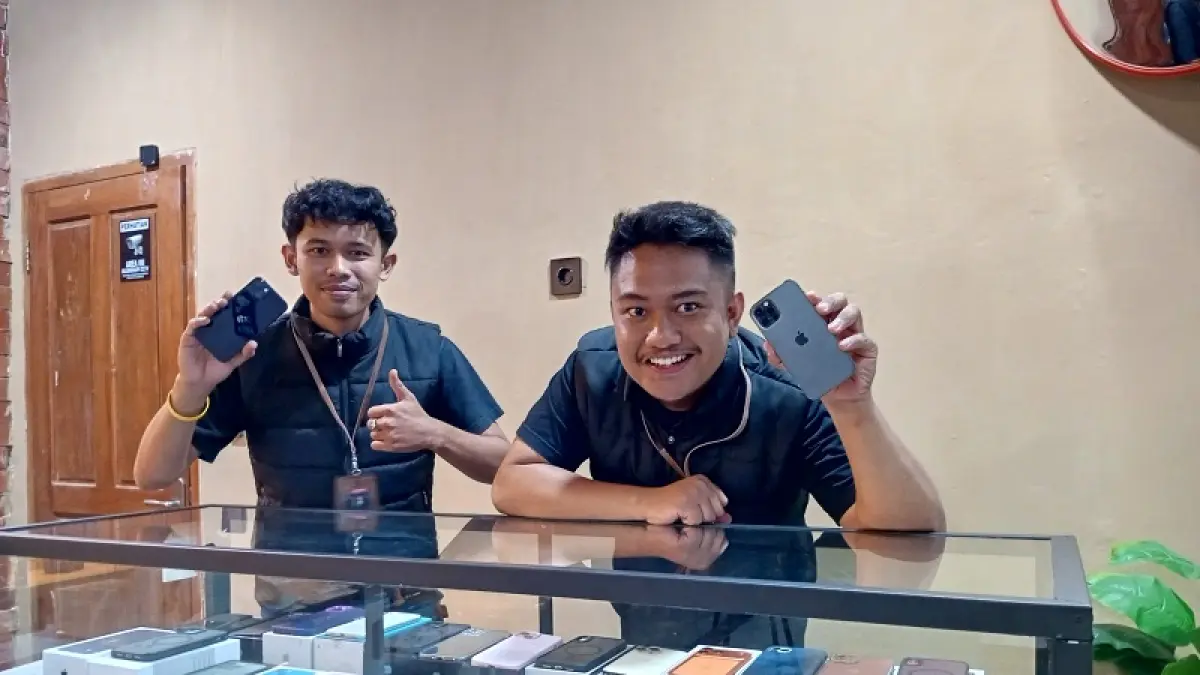 SUKSES: Pemilik persewaan Ras Kamera Riyan Andi Setiyawan (sebelah kanan) dan pekerja tokonya sedang menunjukkan iPhone yang siap disewakan. Yusuf Bastiar/Radar Jogja
