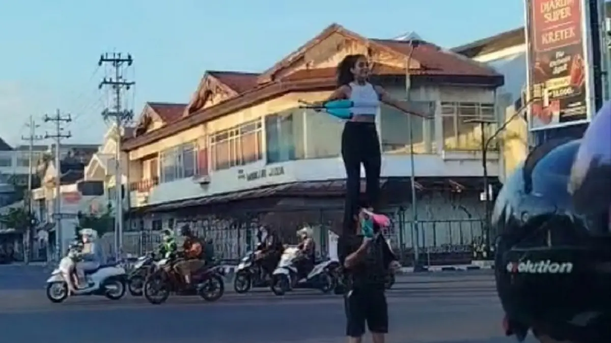 ATRAKSI: Kedua WNA yang kedapatan melakukan aksi ngamen akrobatik di Simpang Empat Gondomanan, Senin (13/4/2026). ISTIMEWA
