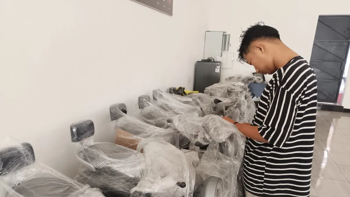 Penjaga showroom sepeda listrik di Jalan HM Sarbini Kebumen sedang mengecek kondisi barang sebelum jatuh ke tangan konsumen. (M Hafied/Radar Jogja)