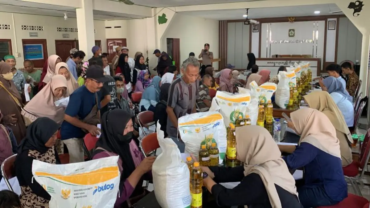 Petugas penyalur memeriksa data penerima dan mendokumentasikan proses penyaluran bantuan di Kulon Progo. (ANOM&nbsp;BAGASKORO/RADAR JOGJA)