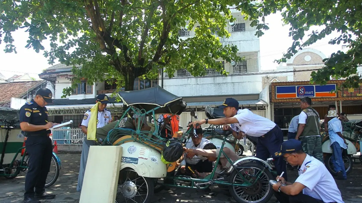 Petugas Dishub DIY melakukan pengecekan fisik kendaraan becak listrik di Tempat Khusus Parkir (TKP) Ketandan, Kota Jogja, Rabu (15/4/2026). Kegiatan tersebut bertujuan memastikan operasional becak kayuh dengan penguat tenaga listrik tetap berjalan dalam kondisi layak, aman, dan tertib di kawasan perkotaan. Guntur Aga Tirtana/Radar Jogja.

