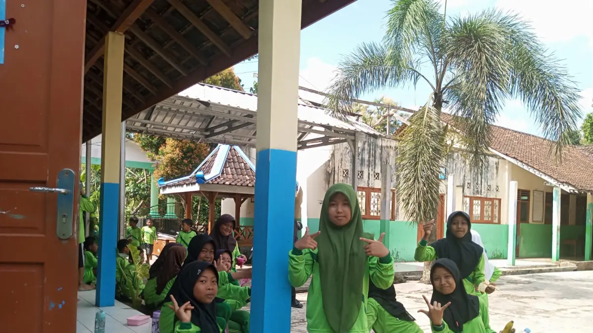 Yusuf Bastiar/Radar Jogja: Siswa SD Kepek 1 Saptosari sedang menyantap menu MBG tepat di depan gedung perpustakaan yang rusak parah.