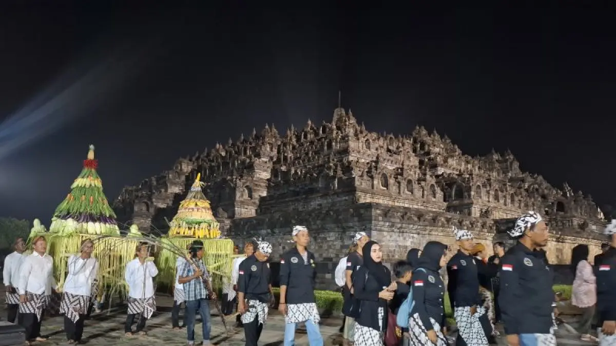 TRADISI: Warga mengarak gunungan palawija mengelilingi Candi Borobudur pada Kirab Pusaka Nusantara, Jumat malam (17/4). (NAILA&nbsp;NIHAYAH/RADAR JOGJA)