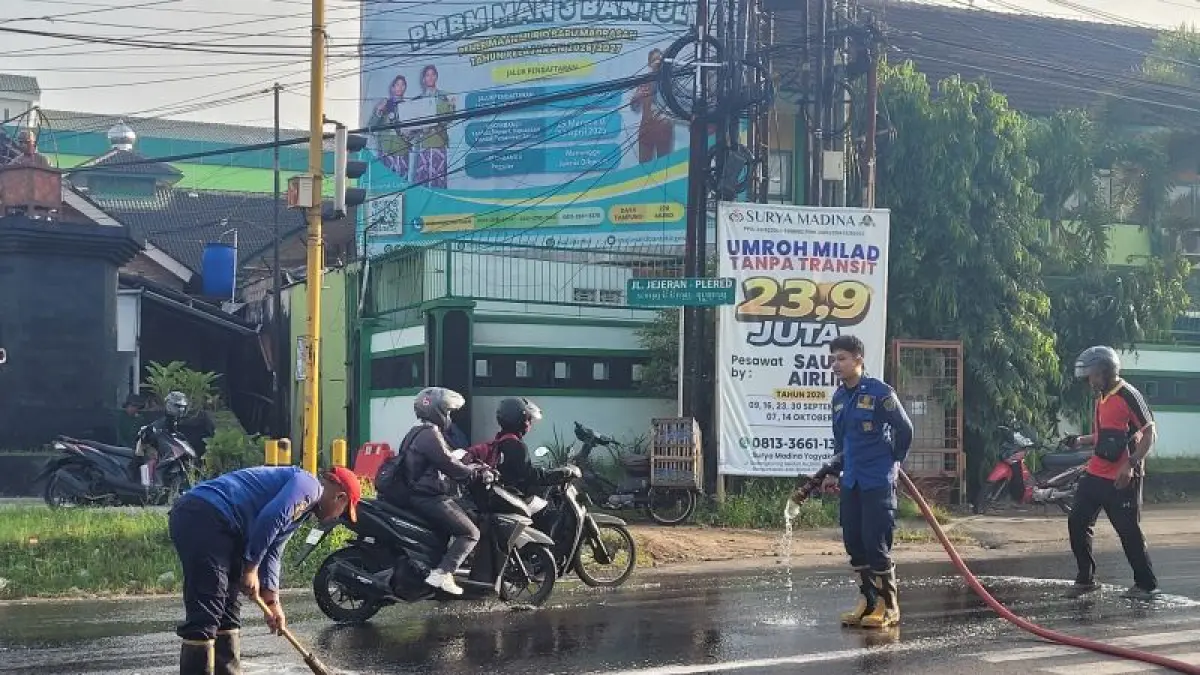 GERAK CEPAT: Petugas Damkarmat BPDB Bantul sedang menyemprotkan air ke tumpahan solar yang berada di simpang empat Jejeran, Pleret Senin (27/4).&nbsp;(Dokumentasi BPBD Bantul)